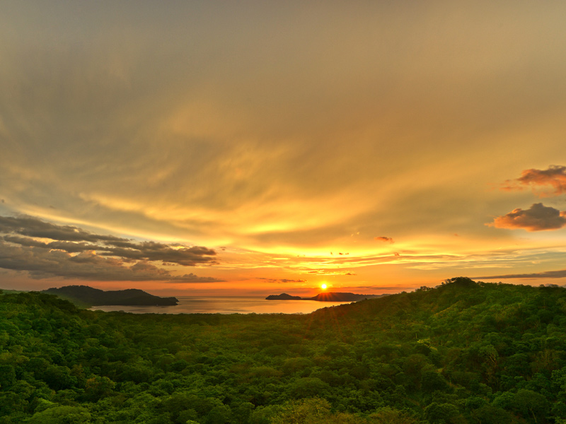 Golden sunset over the lush hills and coastline of Costa Rica