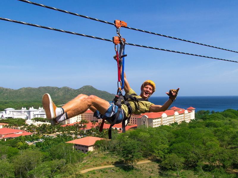 Person zip lining over a resort and the ocean in Guanacaste